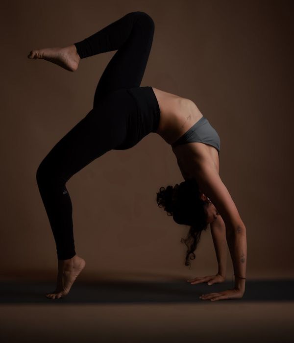 Woman in a calm yoga pose against a dark, minimalist background.